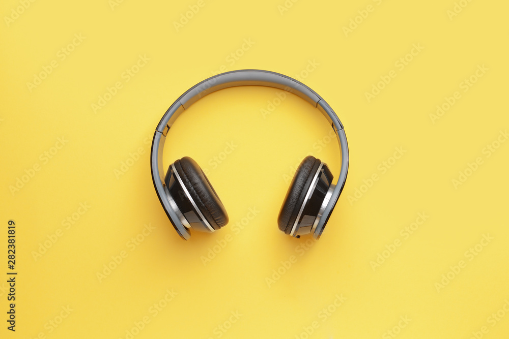 Modern headphones on color background