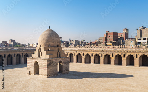 Courtyard of Ibn Tulun public historical mosque with ablution fountain and arched passages, Medieval Cairo, Egypt