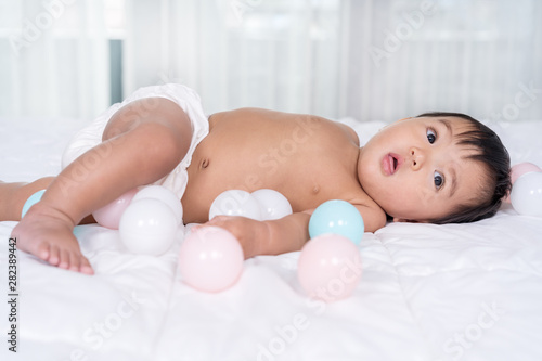 baby playing color ball on a bed