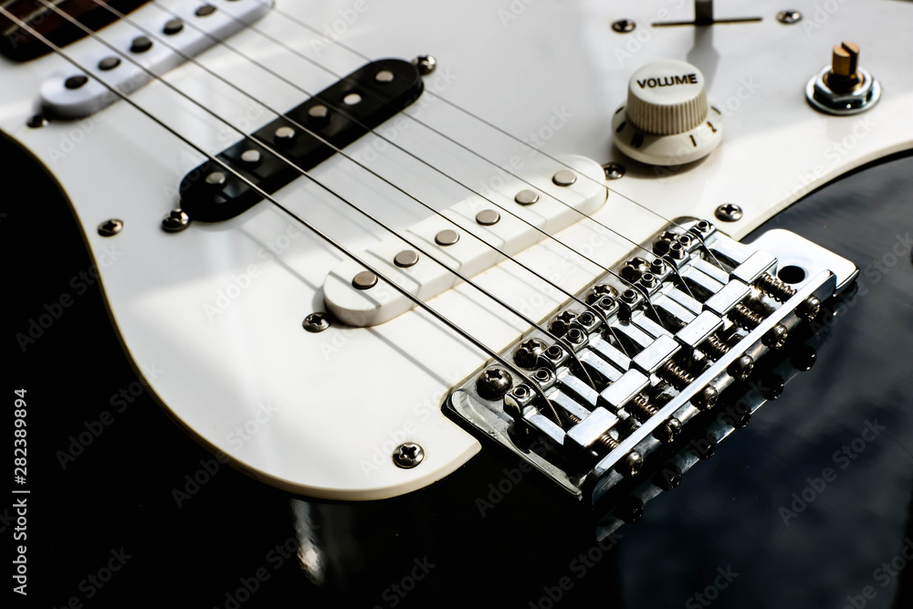 Close up view of the rock electronic quitar. Black and white quitar. Musical concept. Close up view of the rock electronic quitar. Black and white quitar. Musical concept.