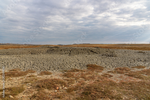 The endless steppe of the Opuksky nature reserve with yellow grass in cloudy weather with clouds on the sky  shot during the season of golden autumn. Yellow-golden-brown color.