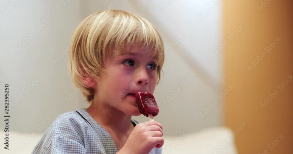 Vidéo Stock Little boy child eating ice cream dessert while watching