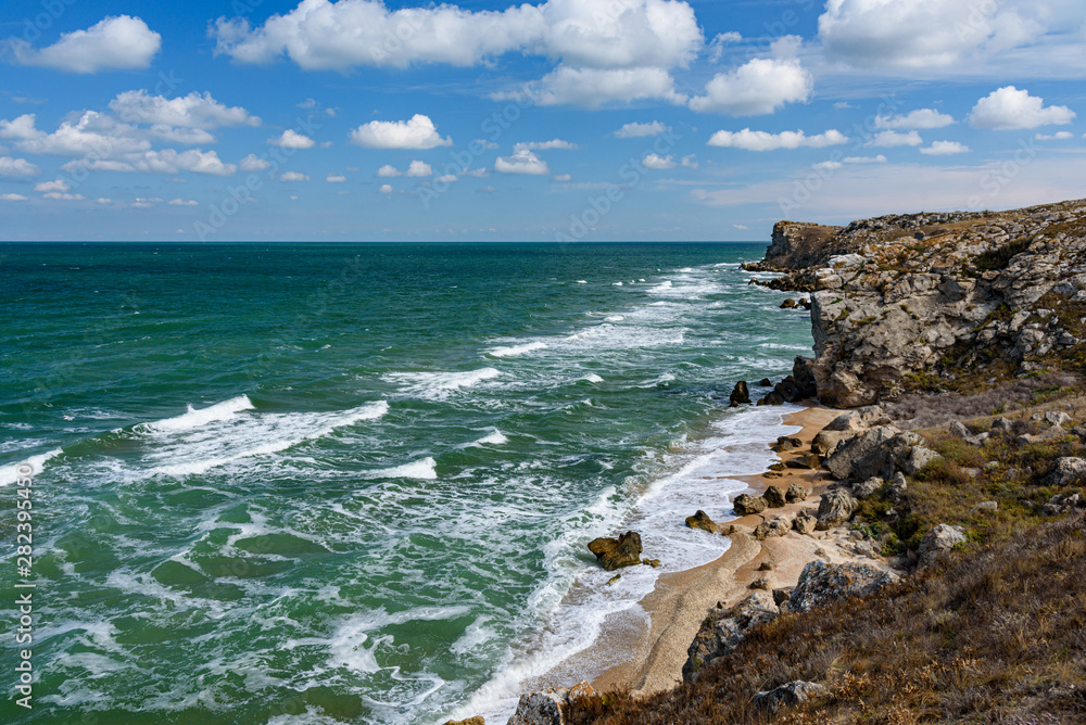 The general's beaches of the Crimean peninsula on a sleepy day with clouds in the sky, cows grazing in the steppe expanses, filmed in the season of golden autumn yellow-golden brown.