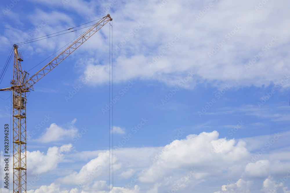 Copy space near construction crane against blue cloudy sky Copy space near construction crane against blue cloudy sky