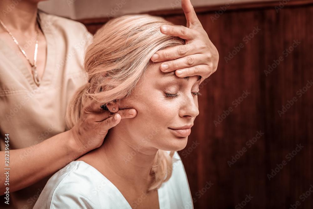 Naklejka premium Relaxed woman getting her head massage in salon.
