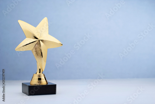 Fotografie Star shaped golden trophy for rewarding in contest