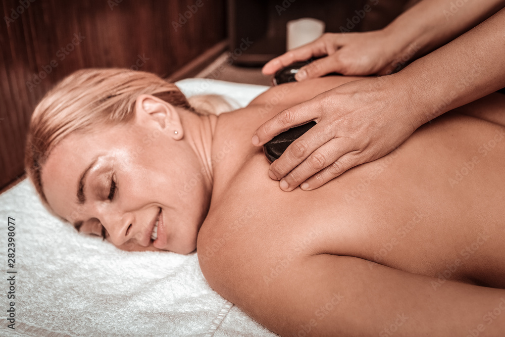 Beautiful woman enjoying her hot stone massage. Beautiful woman enjoying her hot stone massage.
