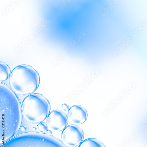 Abstract air bubbles in water on bright cyan blurred background