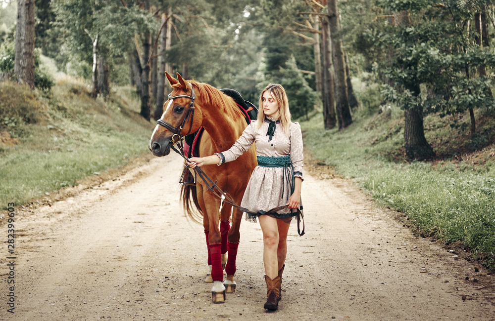 beautiful girl goes on the road with a horse. beautiful girl goes on the road with a horse.