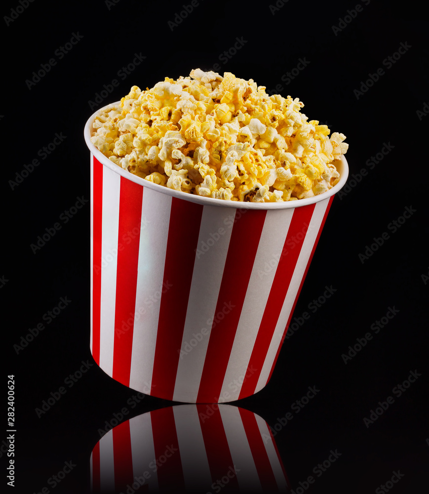 Paper striped bucket with popcorn isolated on black background Paper striped bucket with popcorn isolated on black background