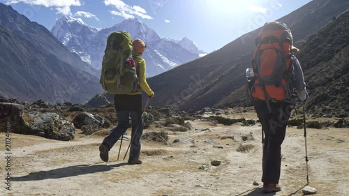 Two tourists on the way to Everest base camp in Himalayas, Nepal. Gimbal, slow motion shot photo