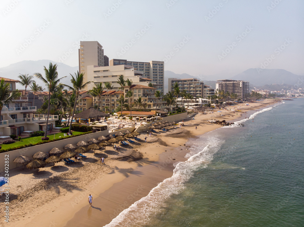 Aerial photos of the beautiful beach and town of Puerto Vallarta in Mexico, the town is on the Pacific coast in the state known as Jalisco with the mountains in the background on a cloudy day. Aerial photos of the beautiful beach and town of Puerto Vallarta in Mexico, the town is on the Pacific coast in the state known as Jalisco with the mountains in the background on a cloudy day.