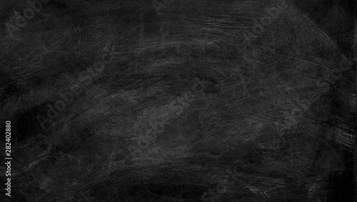 Black chalk board texture background. Chalkboard, blackboard, school board surface with scratches and chalk traces. Wide banner.