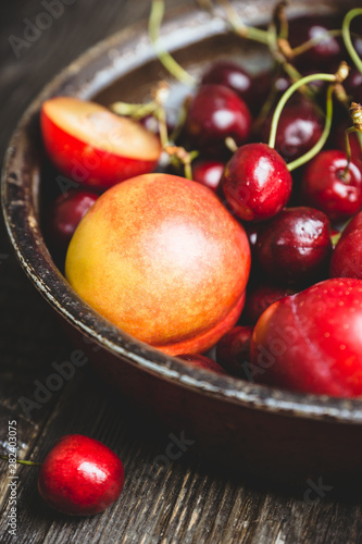 Ripe plums, nectarines and cherries in rustic pan. Selective focus.