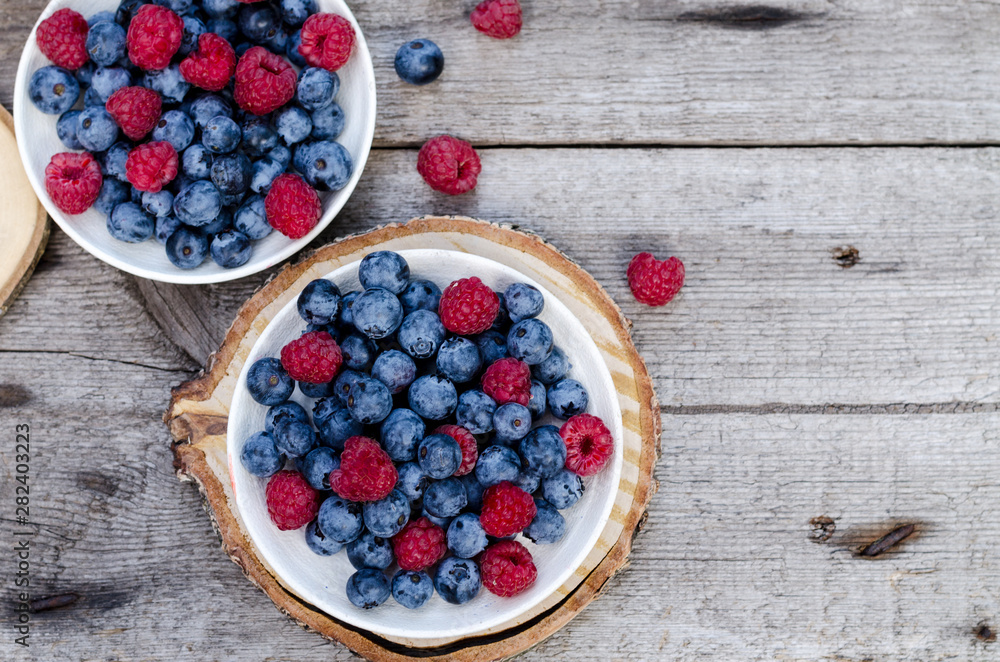 Still life with a blueberries and raspberries on an old wooden table, at the garden. Rural natural food style. Still life with a blueberries and raspberries on an old wooden table, at the garden. Rural natural food style.