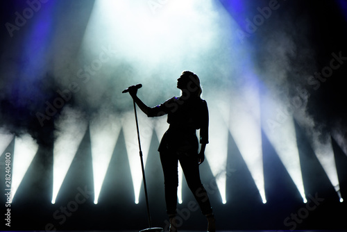 Vocalist singing to microphone. Singer in silhouette