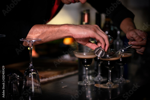 High ISO.The bartender with a cocktail is preparing a cocktail at the bar. Alcoholic beverages, people and luxury concepts.barman making cocktail at nightclub