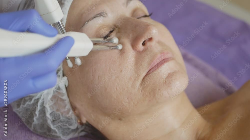 Microcurrent therapy close up. Hands of cosmetologist, female face. Skin care technologies research. Microcurrent therapy close up. Hands of cosmetologist, female face. Skin care technologies research.