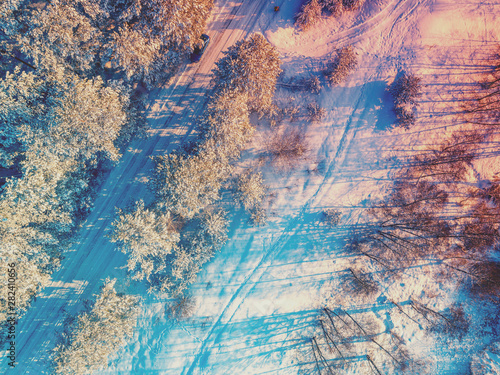 Winter landscape. Pine snowy forest. Trees covered with snow. Aerial view of the road in the winter pine forest