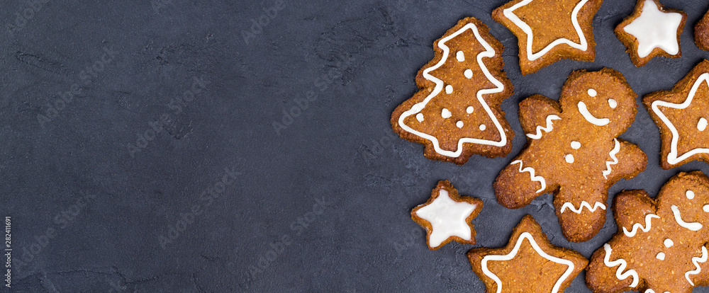 Christmas cookies - star, tree shapes, gingerbread man, white glaze on gray concrete background. Recipe, invitation concept. Top view, flat lay, close-up, copy space, layout design, horizontal banner