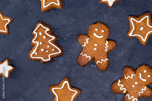 Christmas cookies pattern - star, tree shapes, gingerbread man with white glaze on gray concrete background. Recipe, invitation concept. Top view, flat lay, close-up, copy space, layout design