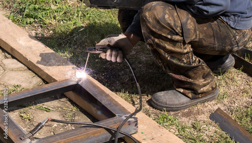 professional welder welds metal parts by electric welding © Irina