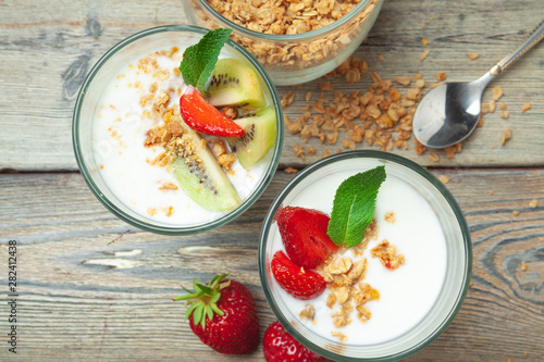 Healthy breakfast with yogurt, berries and granola on wooden table top view