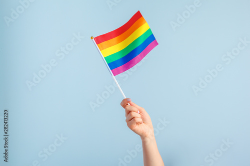 Foto Gay flags in women's hand on grey background