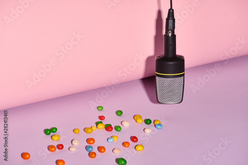 black microphone with candies on bright and colorful background with copy space photo