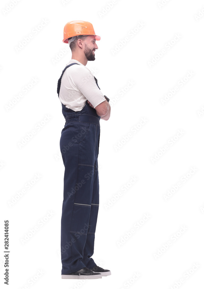 in full growth. smiling man in overalls and a safety helmet in full growth. smiling man in overalls and a safety helmet