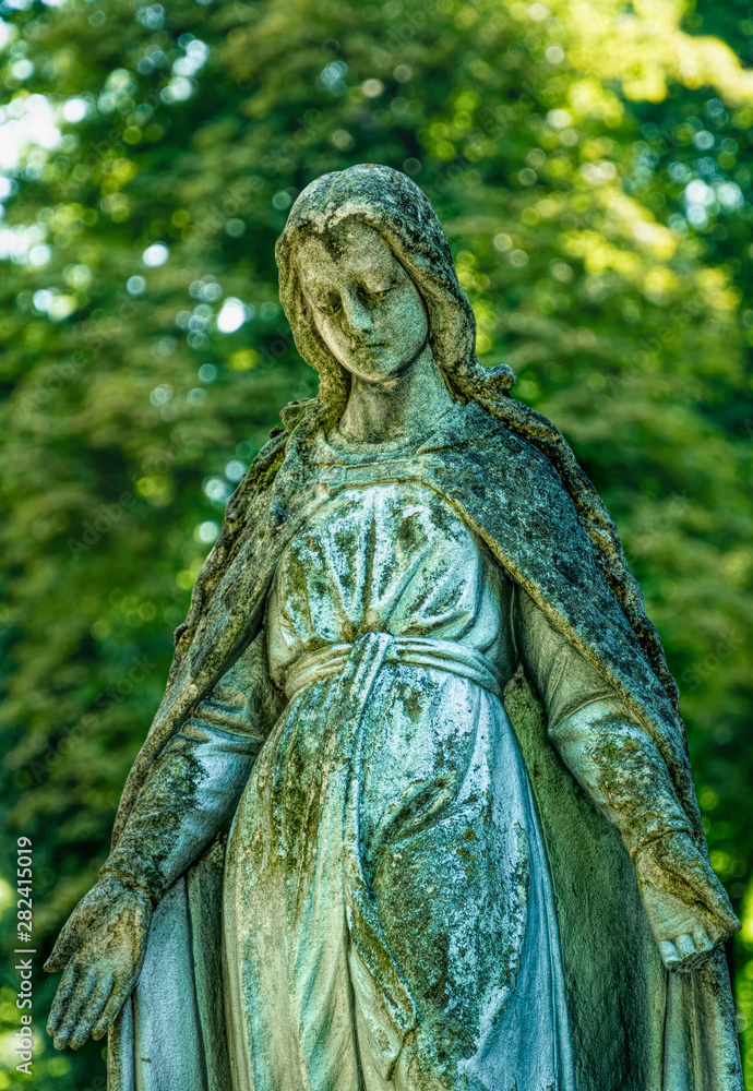 Marble statue and an ancient abandoned Gothic cemetery