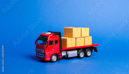 A red truck loaded with boxes. Transportation company. Services transportation of goods and products, logistics and infrastructure. Warehousing and supply. Optimization of delivery logistics.