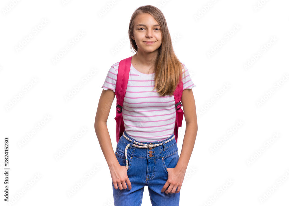 Obraz premium Student teen girl with backpack looking at camera. Portrait of cute smiling schoolgirl with hands in pockets, isolated on white background. Happy child Back to school.
