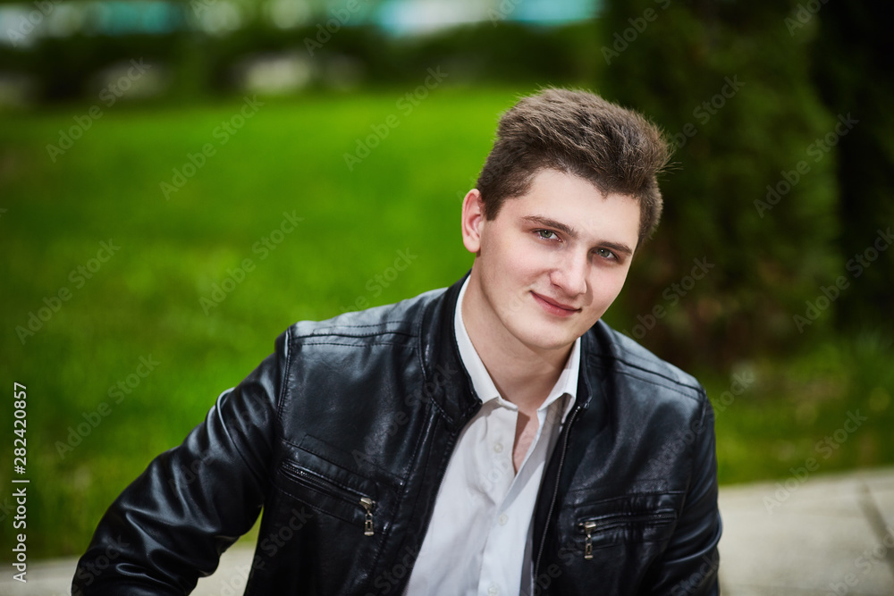 Closeup portrait of a guy in a leather jacket. Looks at the camera. Horizontal frame Closeup portrait of a guy in a leather jacket. Looks at the camera. Horizontal frame