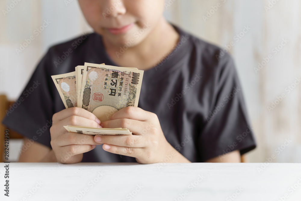 1万円札を数える小学生の男の子 1万円札を数える小学生の男の子