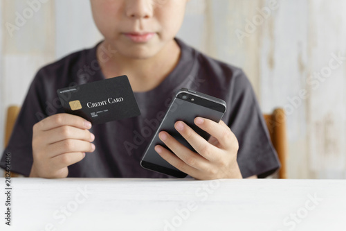 クレジットカードでスマホゲームに課金しようとする小学生の男の子