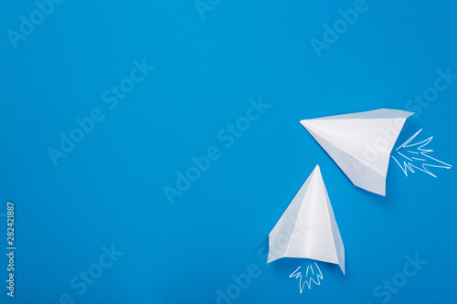 white paper airplane on a navy paper background