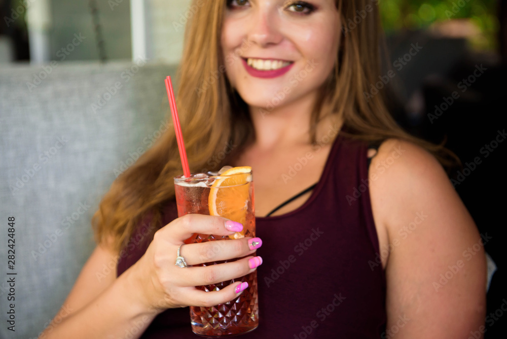 A woman of plus size enjoying life, drinking lemonade. A young lady with natural beauty. XXL model. A woman of plus size enjoying life, drinking lemonade. A young lady with natural beauty. XXL model.