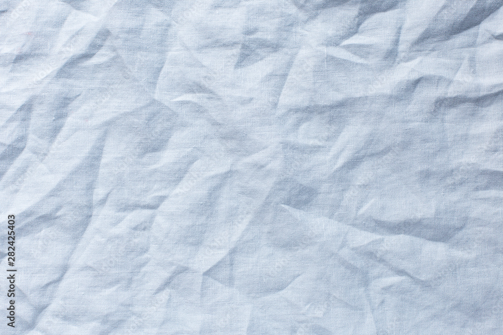 Fototapeta premium light blue background with crumpled linen cloth