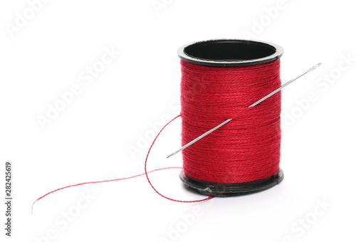 Spool of sewing threads with needle isolated on white background