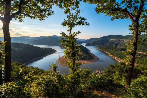 Bulgaria, Kardzhali dam, view of meander in Arda river, surrounded with green forest, summer time during sunset