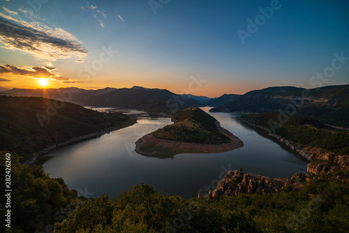 Bulgaria, Kardzhali dam, view of meander in Arda river, surrounded with green forest, summer time during sunset