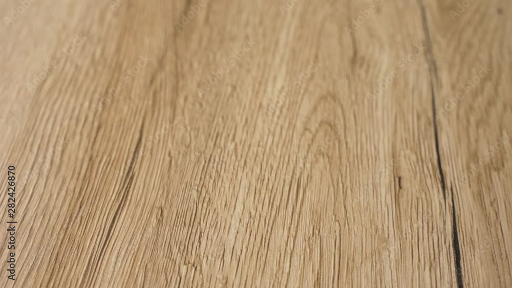 Close prospective view of the finished smooth wood floor with modern style and finest clear natural colors of maple hard wood boards. Home improvement and renovation concept in 4k slow motion. Close prospective view of the finished smooth wood floor with modern style and finest clear natural colors of maple hard wood boards. Home improvement and renovation concept in 4k slow motion.