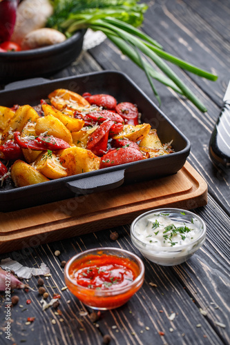 Potato baked with sausages along with white and red sauce