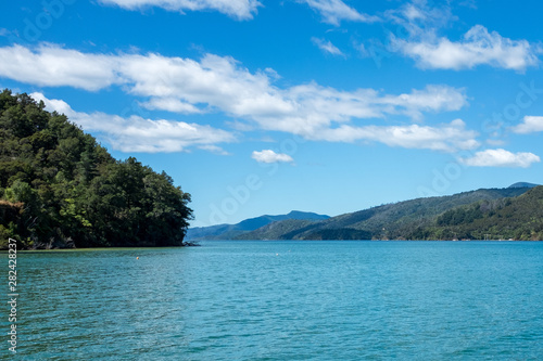 A water level view of the beautiful and stunning Marlborough Sound and the surrounding hills at the top of the South Island, New Zealand on a sunny day.