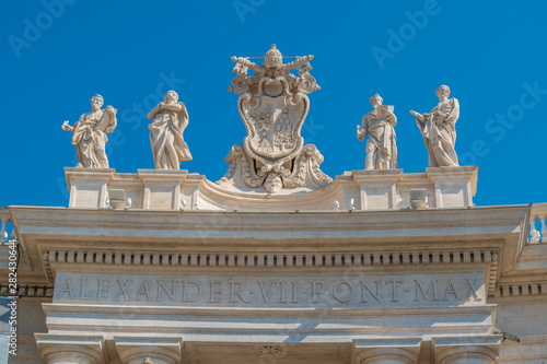 Alexander VII coat of arms and saints statues (Mark, Mary, Ephraim and Theodosia) in the colonnade of Saint Peter Basilica in the Vatican