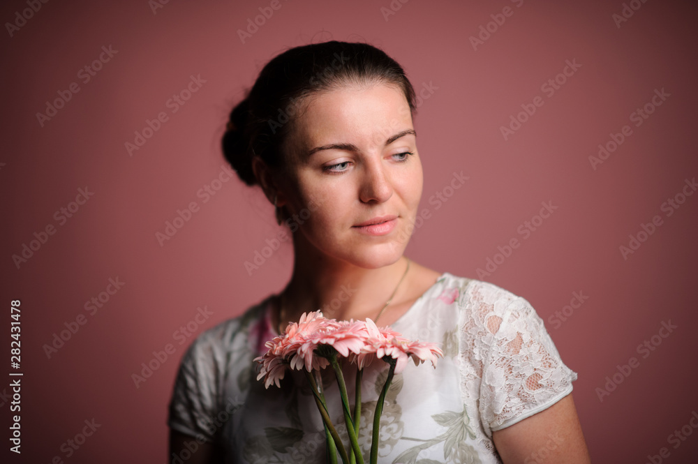 smiling woman with pink flowers. Studio pink background smiling woman with pink flowers. Studio pink background