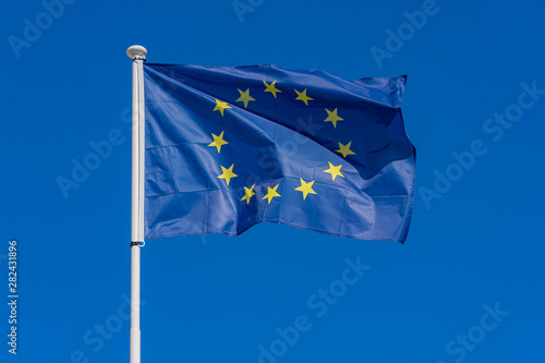 European Union flag blowing in wind in front clear blue sky