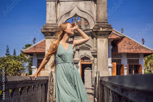 Young woman in dress in Water Palace Soekasada Taman Ujung Ruins on Bali Island in Indonesia. Amazing old architecture. Travel and holidays background