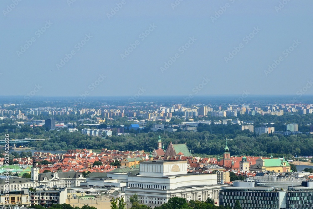 Aerial cityscape of Warsaw city from the viewpoint located on the 30th floor of Palace of Culture and Science. Old town of Warsaw with red roofs in the distance. Warsaw, Poland